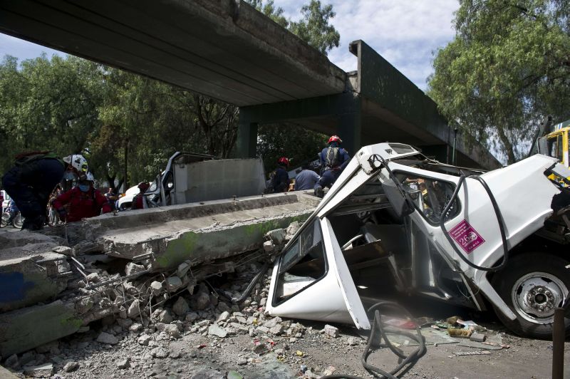 Bombeiros trabalham para remover um ônibus danificado por uma ponte que desabou, após o terremoto que atingiu o México | AFP PHOTO / RONALDO SCHEMIDT