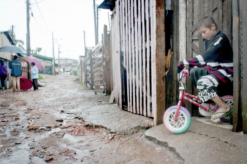 Menino observa o estrago causado pela chuva no bairro Boqueirão | Daniel Caron/ Gazeta do Povo