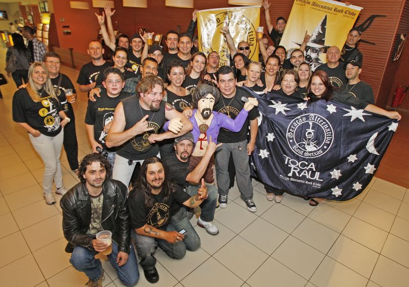 Integrantes do fã-clube no cinema: Fabiano, o presidente, está à direita do boneco de Raul Seixas | Hugo Harada/Gazeta do Povo