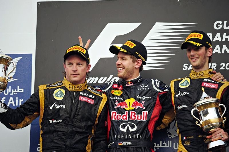 Sozinho entre os pilotos da Lotus no pódio, Vettel abraça Romain Grosjean e faz graça com Kimi Raikkonen | Dimitar Dilkoff/ AFP