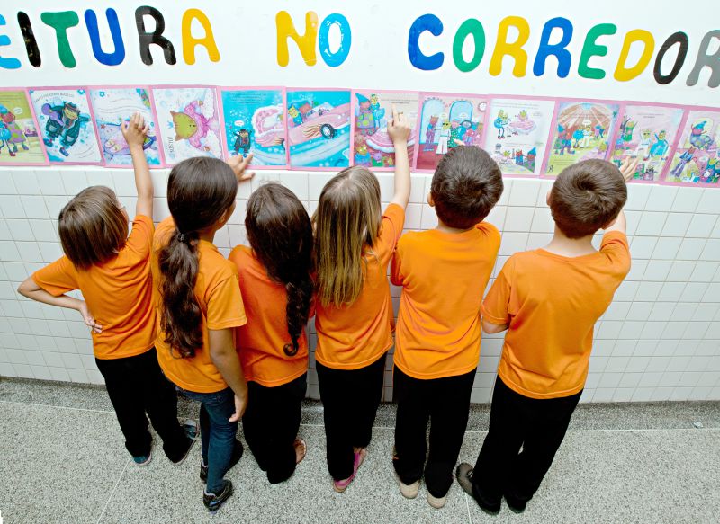 Crianças da Escola Municipal Maria de Lourdes Pegoraro, no Cajuru, leem livro mural a caminho da sala de aula | Henry Miléo / Gazeta do Povo