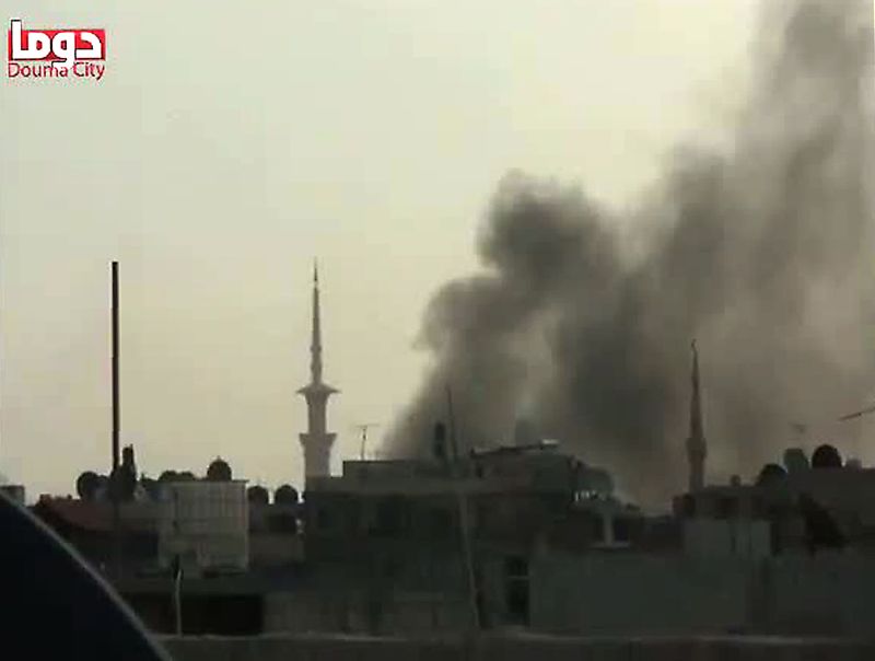 Imagens de vídeo no YouTube mostra fumaça saindo de um prédio em Douma, na Síria | AFP PHOTO/YOUTUBE