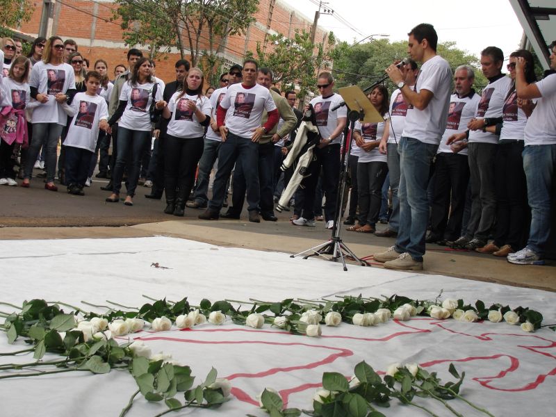 Com camisetas que estampavam a foto do policial morto, amigos e colegas de trabalho colocaram rosas brancas no local onde ele caiu morto e depois fizeram, de mãos dadas, uma oração | Luiz Carlos da Cruz
