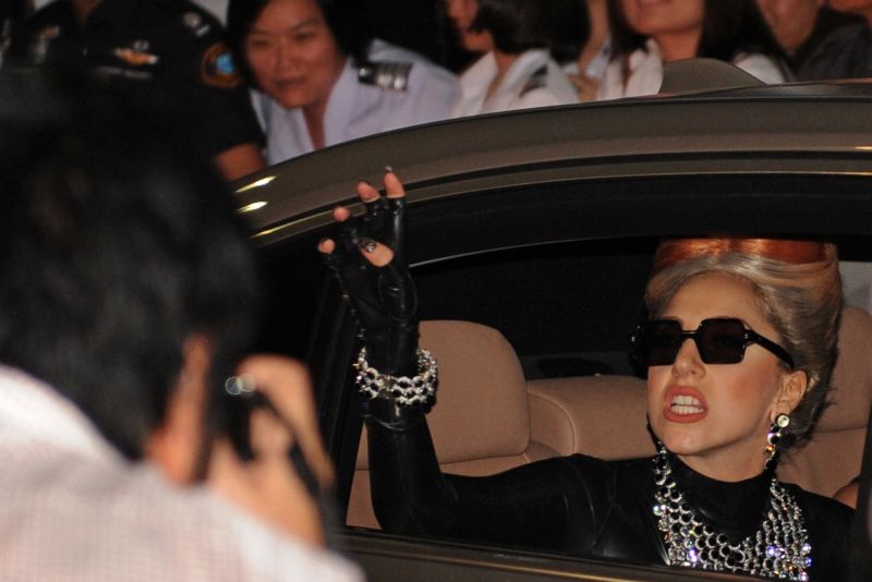 STF Pop diva Lady Gaga waves to fans as she leaves the airport following her arrival in Bangkok on May 23, 2012. Lady Gaga chega à Tailândia, um dos países que fazem parte do seu tour pela Ásia | AFP PHOTO/Christophe ARCHAMBAULT