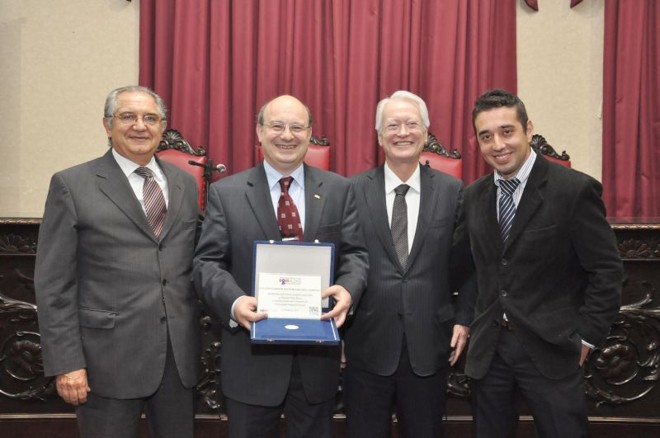 Ao dar às boas-vindas aos 11 novos calouros do Programa Bom Aluno, na última quarta-feira, o reitor da UFPR, Zaki Akel Sobrinho, recebeu uma homenagem pelos 100 anos da instituição dos empresários Ozil Coelho Neto (1º à esq.) e Francisco Simeão (2º da dir. para a esq.). Diego Bergamini (último à dir.), ex-aluno do programa, também participou da recepção |