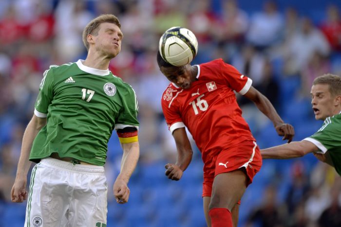 Suíço Fernandes disputa a bola com o alemão Mertesacker: às vésperas da Eurocopa, Alemanha é surpreendida | AFP