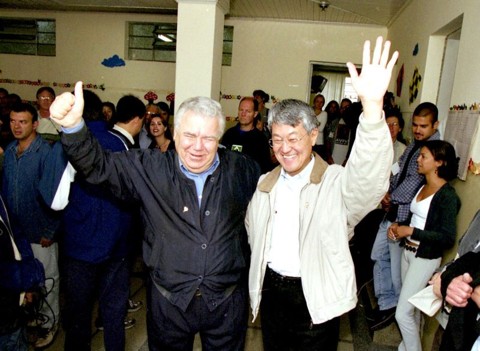 2000: Para se reeleger, Taniguchi copia o PT e foca no social Taniguchi no dia da eleição do segundo turno de 2000, ao lado de Lerner: governador paranaense mal apareceu durante a campanha para não prejudicar a reeleição do prefeito | Arnaldo Alves/ Arquivo/ Gazeta do Povo
