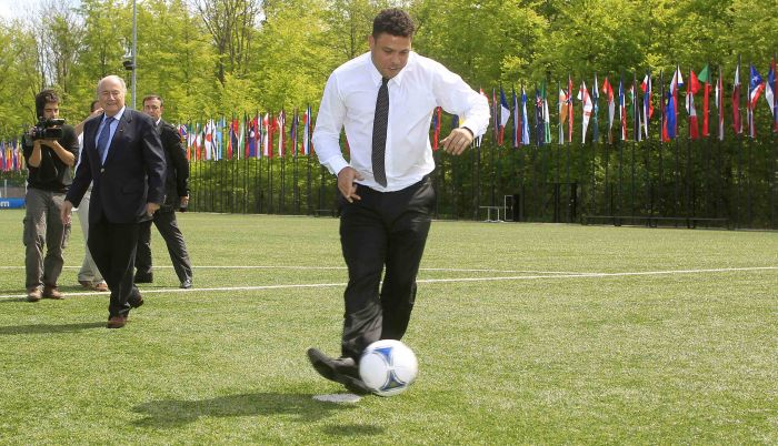Mesmo engravatado, o ex-jogador Ronaldo, hoje membro do COL, bate pênalti em momento descontraído do encontro em Zurique | Arnd Wiegmann/Reuters