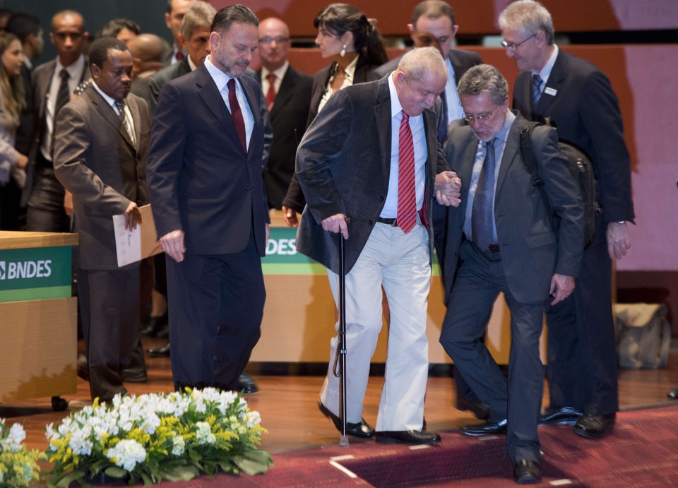 Lula é amparado pelo presidente do BNDES, Luciano Coutinho, durante o seminário no Rio | Christophe Simon/AFP Photo