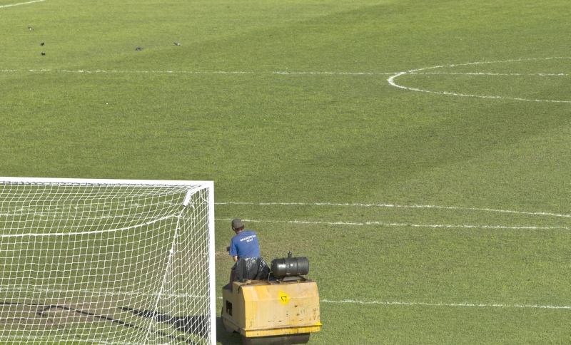 Funcionário paranista tentou ontem amenizar os problemas do irregular gramado do Durival Britto. Clube lamenta a situação | Antonio Costa/ Gazeta do Povo