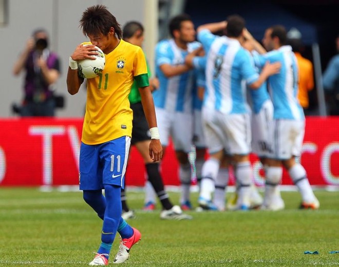 Neymar carrega a bola de cabeça baixa enquanto argentinos comemoram | 