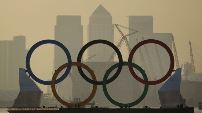 Balsa navega pelo Rio Tâmisa com os arcos olimpícos com Londres ao fundo | 