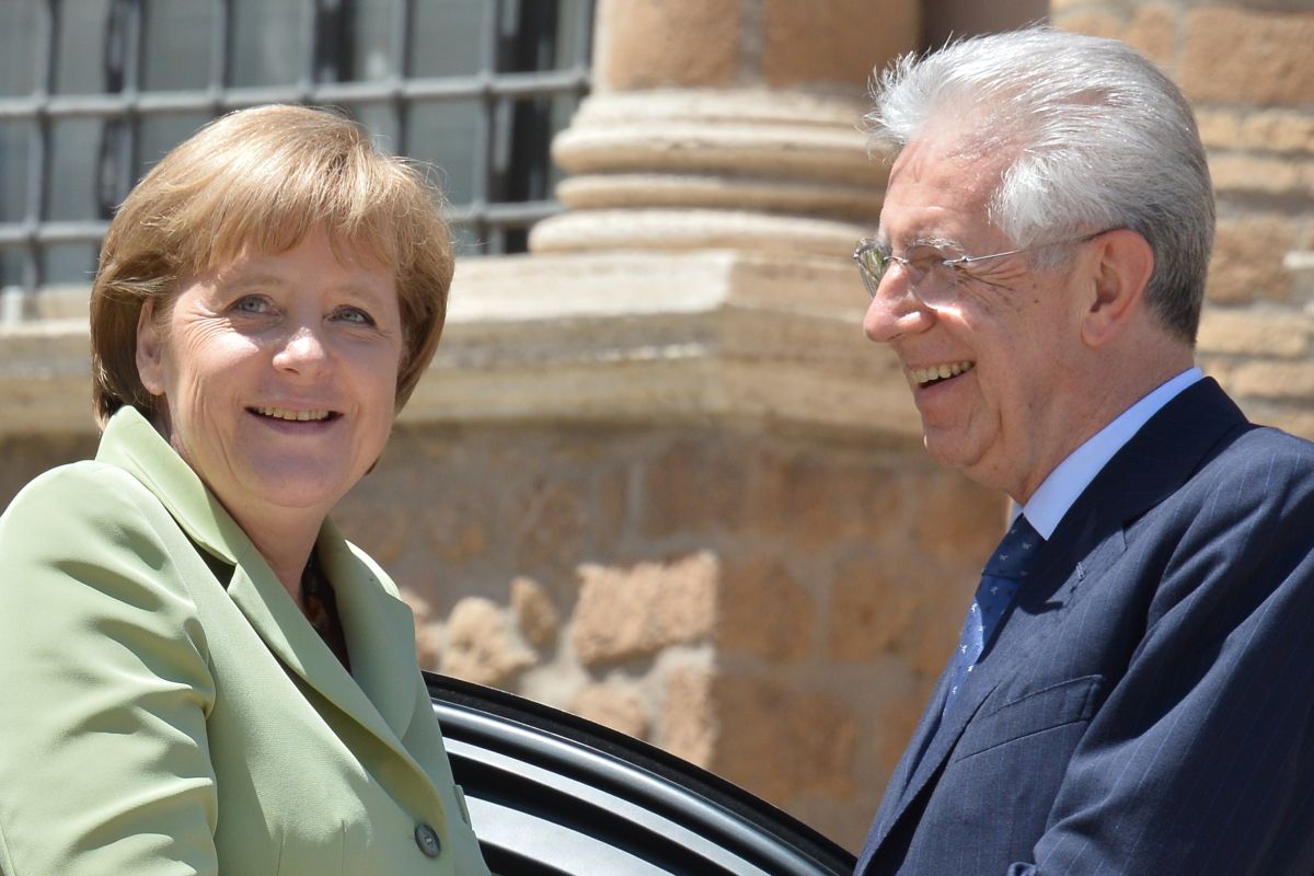 A chanceler alemã, Angela Merkel, e o primeiro ministro italiano, Mario Monti, se cumprimentam durante chegada ao encontro | AFP PHOTO / VINCENZO PINTO