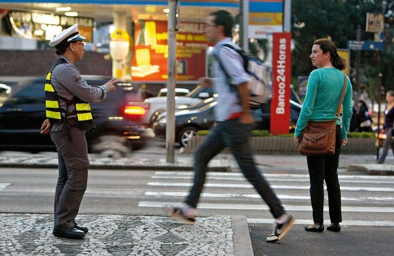 Agente orienta pedestres em Curitiba. Ações educativas são apontadas como uma das medidas para reduzir a violência no trânsito | Hugo Harada/Gazeta do Povo