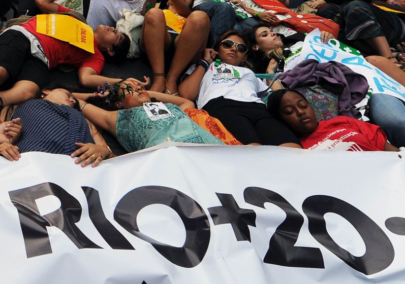 Ativistas deitam no chão durante protesto no centro do Rio | AFP PHOTO / ANTONIO SCORZA