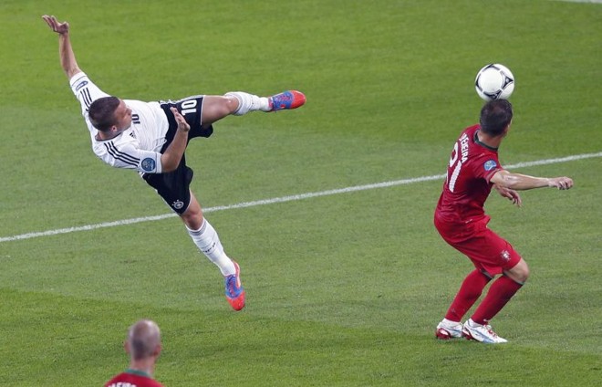 Podolski se estica todo para realizar o chute | 