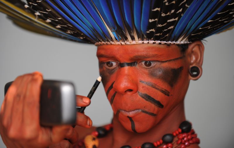 Índio capricha na maquiagem antes da inauguração da Cúpula dos Povos, durante a Rio+20. Painéis temáticos "Diálogos para o desenvolvimento sustentável" começam neste sábado (16) | Vanderlei Almeida/AFP