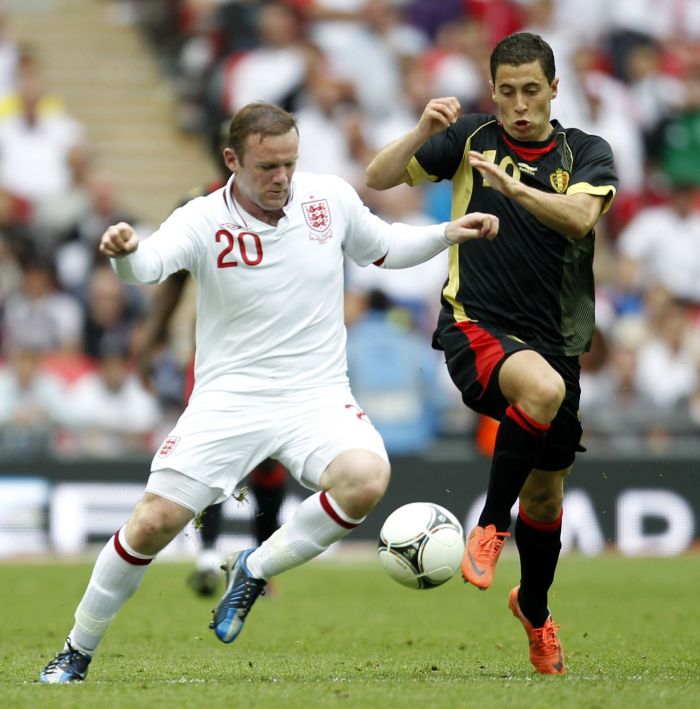 Wayne Rooney (de uniforme branco) disputa a bola pela seleção inglesa com o defensor belga | Ian Kington/AFP