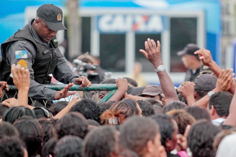 Os catadores foram prensados contra a grade quando tentavam resgatar o cartão da Caixa | Pedro Kirilos/Agencia O Globo
