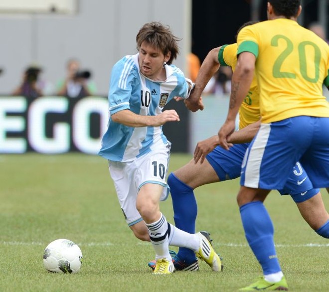 Messi carrega a bola observado por Sandro e Hulk (camisa 20) | 