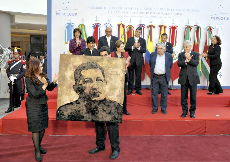 Líderes sul-americanos presenteiam o governo venezuelano com uma pintura do retrato do presidente Hugo Chávez, durante encontro do Mercosul, em Mendoza | Juan Mabromata/AFP