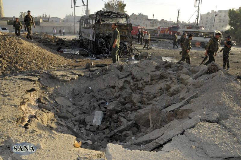 Oficiais de segurança inspecionam local onde um carro-bomba explodiu em Damasco | REUTERS/Sana/Handout