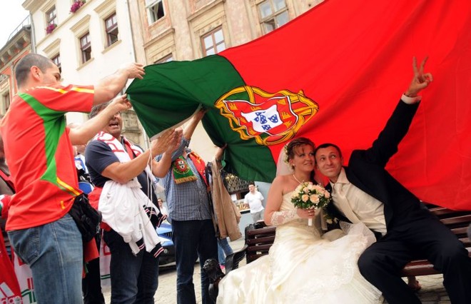 Noivos posam embaixo da bandeira portuguesa | 