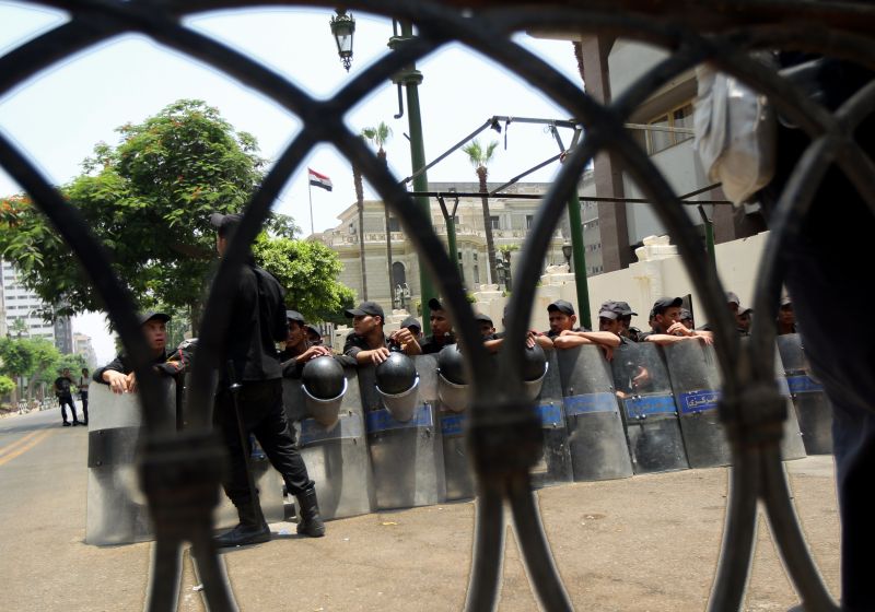 Policiais egípcios se posicionam em frente ao Parlamento do Egito enquanto manifestantes se reúnem do lado de fora dos portões | AFP PHOTO/MARWAN NAAMANI