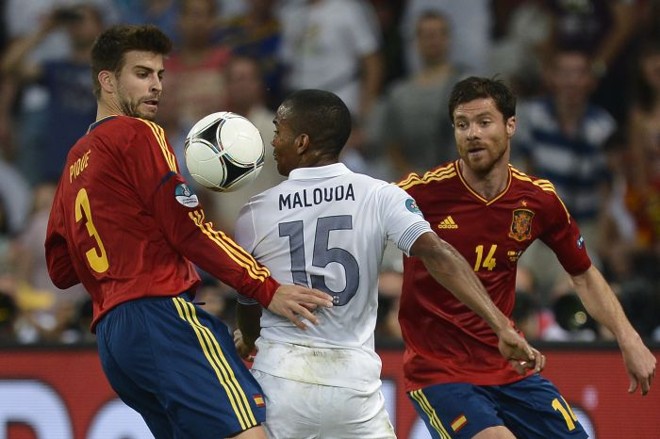Malouda tenta jogada entre os defensores espanhóis Piqué e Alonso |