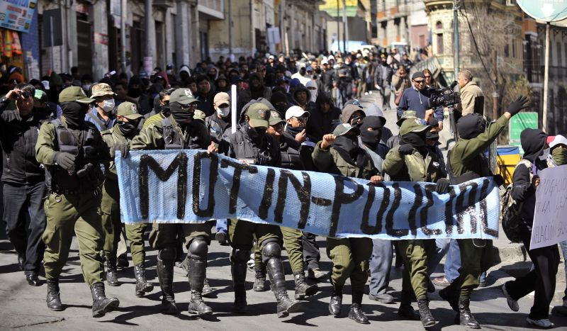 Ao grito de "esta é nossa praça" e "fora masistas" (militantes do governista Movimento ao Socialismo, MAS), os rebeldes, com os rostos cobertos, lançaram-se sobre um pequeno grupo de pessoas favoráveis ao governo | AFP PHOTO/Aizar Raldes