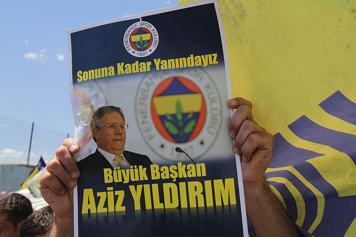 Torcedor ergue cartaz com a foto do presidente do Fenerbahçe, Aziz Yildirim, em protesto contra a condenação do dirigente pela Justiça turca | SAYGIN SERDAROGLU / AFP