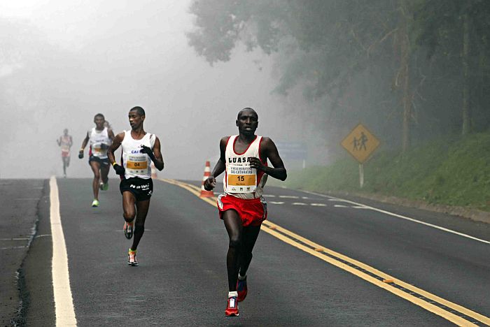 Queniano Ben Kiplimo Mutai encarou o frio em Foz para vencer a Meia-Maratona das Cataratas. Na foto, ele é seguido pelo brasileiro Giovani dos Santos, o segundo colocado | Christian Rizzi / Gazeta do Povo