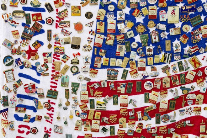 Uma seleção de broches enfeita a bandeira dos Estados Unidos, nas imediações do Parque Olímpico | 
