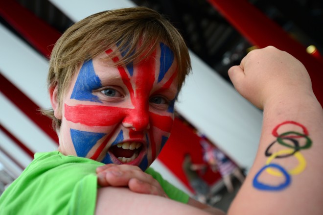 Garoto exibe a bandeira britânica e os anéis olímpicos pintados em seu braço | 