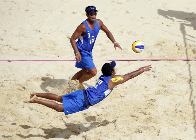 O venezuelano Jesus Villafane Marquina (abaixo) tenta defender um ataque no duelo com a Holanda, no vôlei de praia |