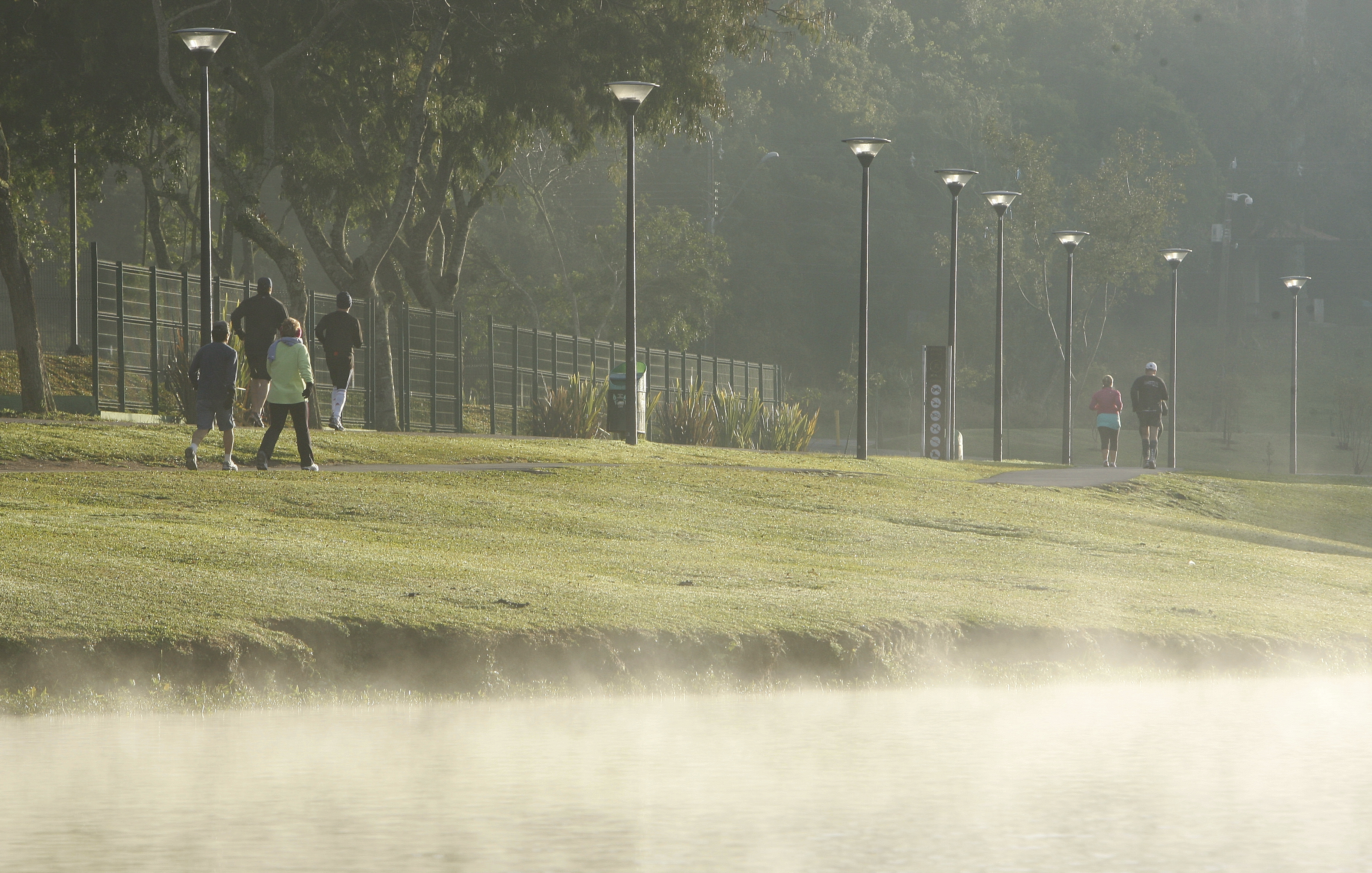 Algumas pessoas enfrentaram o frio desta manhã de sábado (14) e praticaram corrida no Parque Barigui, em Curitiba | Hugo Harada / Gazeta do Povo