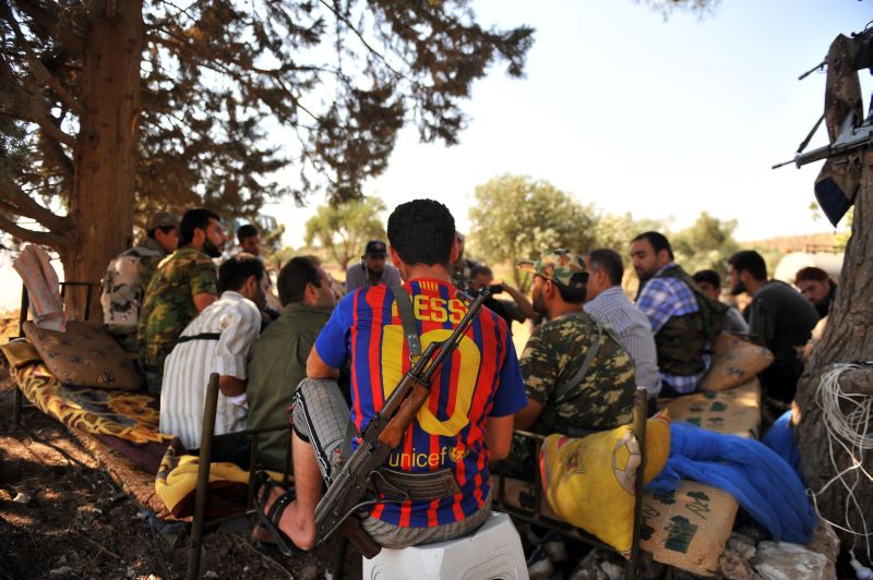 Rebeldes sírio vestido com a camisa do Barcelona descansa com companheiros perto da cidade de Aleppo | AFP PHOTO / BULENT KILIC
