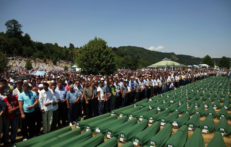 Muçulmanos bósnios rezam durante enterro coletivo de vítimas do massacre de Srebrenica | REUTERS/Dado Ruvic