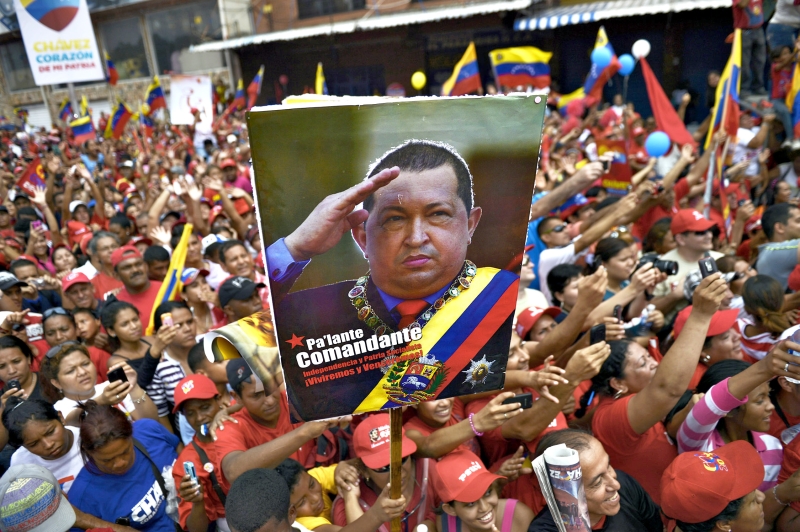 Simpatizantes de Chávez exibem cartaz com foto do presidente venezuelano, que busca a reeleição, durante comício em Caracas | Juan Barreto/AFP