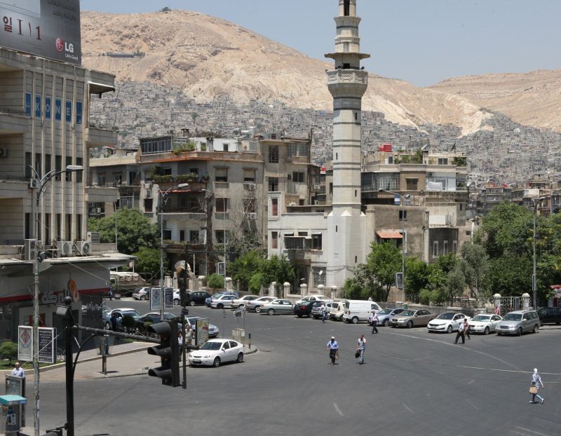 Pessoas cruzam a Praça Sabaa Bahrat, em Damasco, nesta terça-feira | AFP PHOTO/LOUAI BESHARA