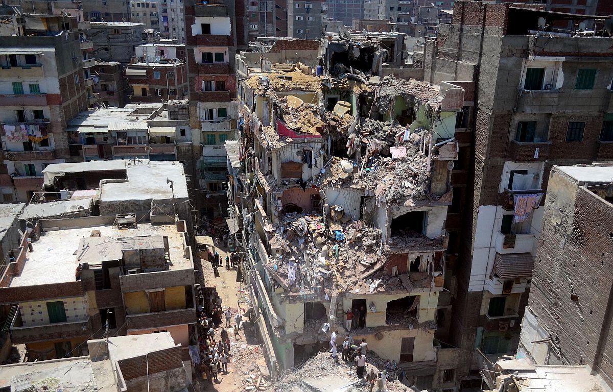 O edifício caiu sobre outros prédios, cinco pessoas ficaram feridas e equipes de resgate estão procurando sobreviventes sob os escombros | AFP PHOTO/STR