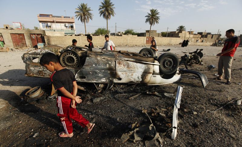 Moradores observam destroços de carro-bomba em Mahmudiya, 30 km ao Sul de Bagdá | Reuters/Mohammed Ameen