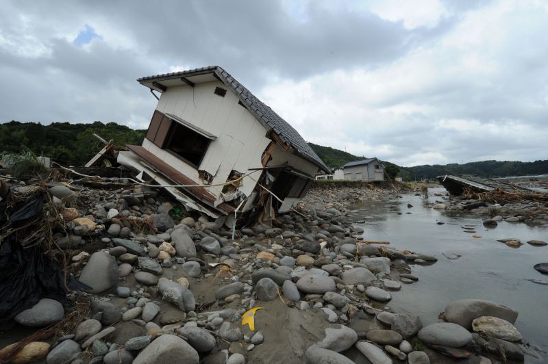 Casa às margens do rio Hoshino desaba por causa das fortes chuvas que já mataram 27 pessoas no Japão | AFP PHOTO / KAZUHIRO NOGI