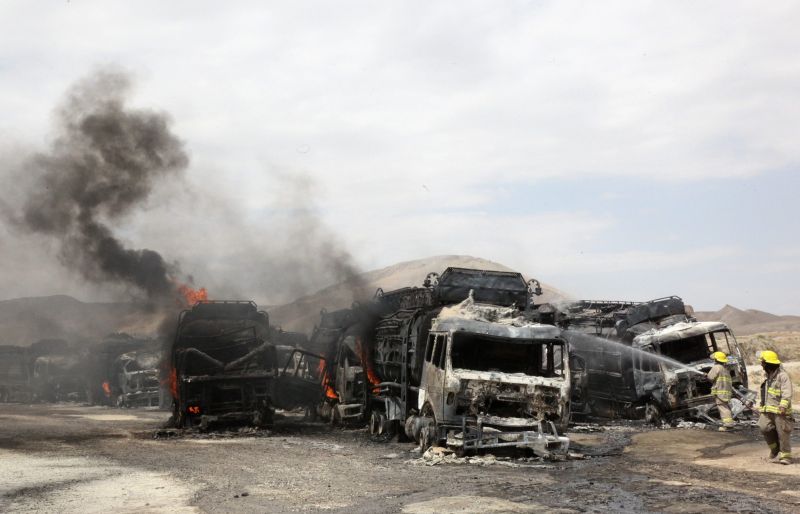 Bombeiros afegãos tentam apagar incêndio causado por explosões de bombas em caminhões da Otan | REUTERS/Stringer