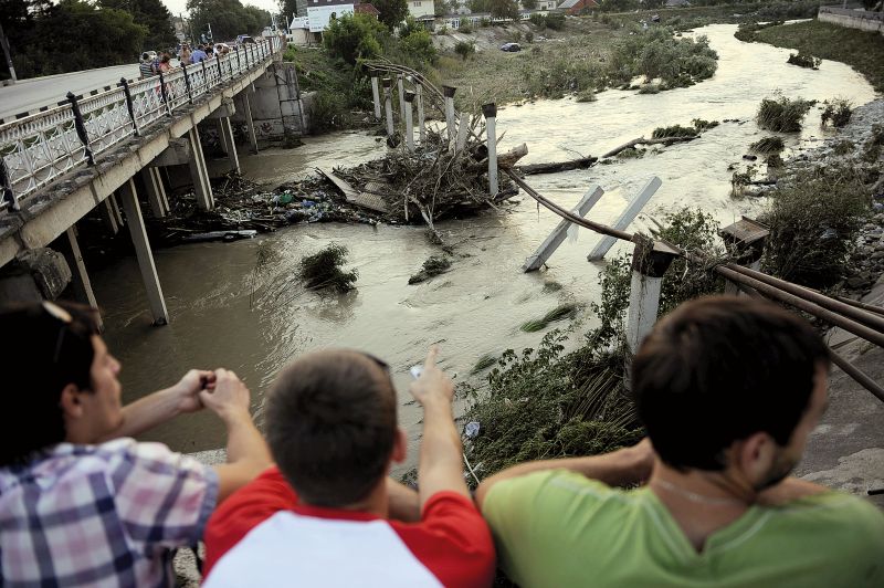 Moradores da cidade de Krymsk observam rio inundado. Pior enchente no sudoeste da Rússia nos últimos 70 anos deixou pelo menos 170 mortos | Mikhail Mordasov/AFP
