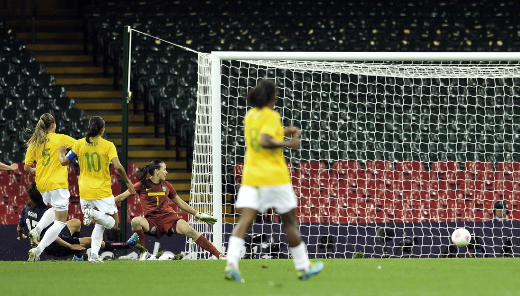 Erika e Marta observam a japonesa Ogimi chutar na saída de Andrea e marcar o primeiro gol do jogo em Cardiff | Glyn Kirk/ AFP