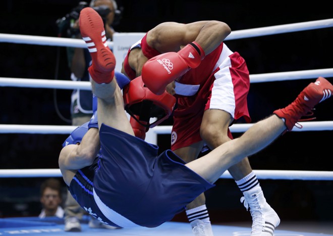 O mongol Munkh-Erdene Uranchimeg (dir) manda para a lona o ucraniano Denys Berinchyk, na semifinal do boxe até 64kg | 