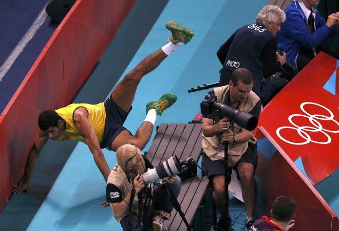 O brasileiro Wallace voa sobre as placas para evitar o ponto argentino, nas quartas de final do vôlei | 