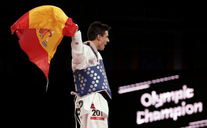Espanhol Joel Gonzalez Bonilla celebra com a bandeira de seu país após vencer o ouro no taekwondo | 