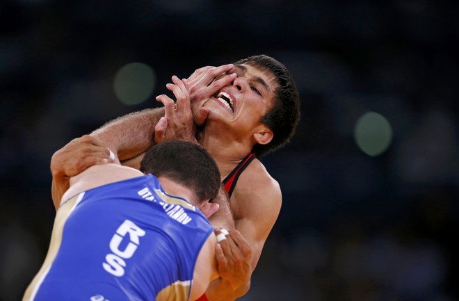 O cazaque Daulet Niyazbekov (vermelho) enfrenta o russo Dzhamal Otarsultanov na luta-livre até 55kg | 